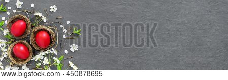 Chicken Nests With Painted Red Easter Eggs On Dark Tabletop. Concept Creative Banner. Holiday Greeti
