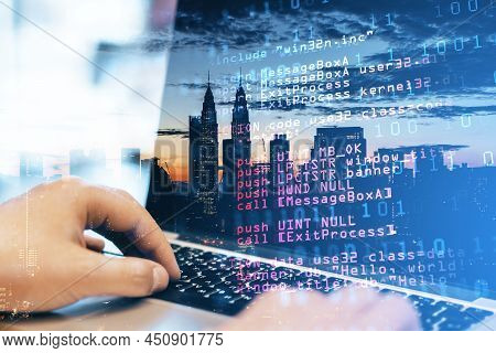 Close Up Of Man Hand Using Laptop Keyboard With Abstract Html Code On Creative City Background. Codi