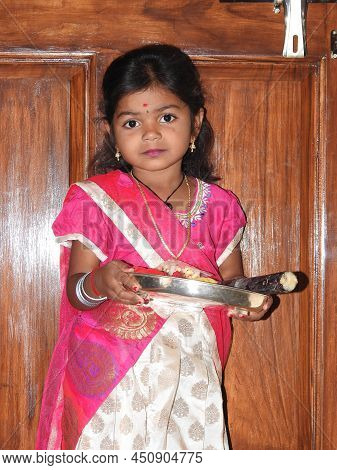 Closeup Of Beautiful Indian Girl Kid Traditionally Dressed To Distribute Makara Sankranti Or Pongal