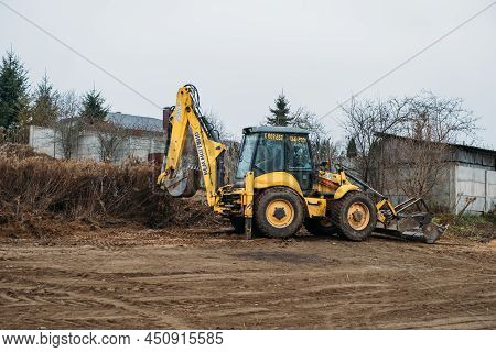 Tractor Levels Field. Backhoe Loader Clearing Construction Site. Bulldozer Prepares Building Ground.