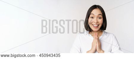 Close Up Portrait Of Young Japanese Woman Showing Namaste, Thank You Arigatou Gesture, Standing Over