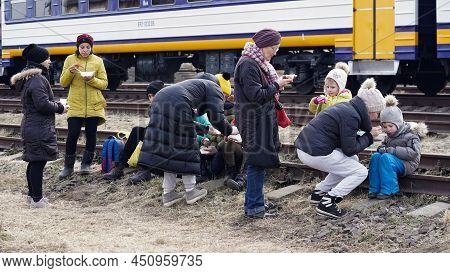 03.03.2022 Ukraine, Women Fed Their Little Children While Sitting On The Railway Tracks During The E
