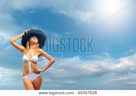 Kvinde i bikini iført en hat af havet