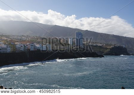 View On Colorful Houses And Black Lava Rocks In Small Village Punta Brava Near Puerto De La Cruz, Te
