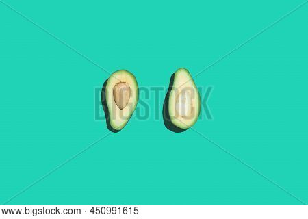 Minimal Top View Of Avocado Half On Contrasted Neon Blue Background, Healthy Eating And Vegan Concep