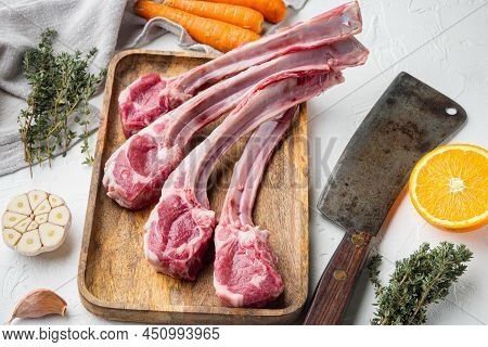 Raw Lamb Chops Or Mutton Cuts Set, With Ingredients Carrot Orange, Herbs, And Old Butcher Cleaver Kn