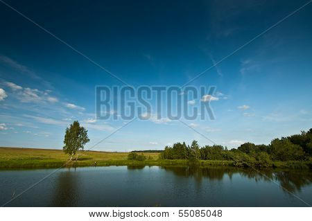 Landscape with blue sky and smooth lake surface