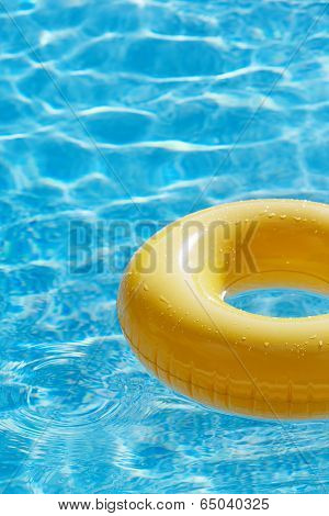 floating ring on blue water swimpool with waves reflecting in the summer sun