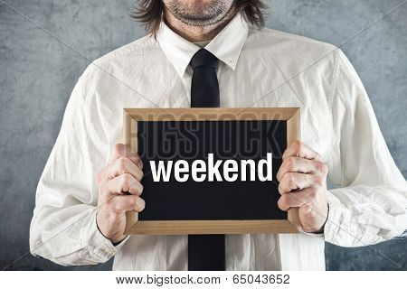 Businessman Holding Blackboard With Weekend Title