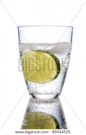 a glass of fresh drinking water and a lime. mineral water as a thirst quencher.