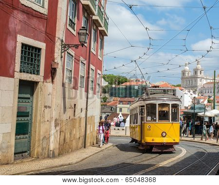 LISBON, PORTUGAL - APRIL 18, 2014: Very touristic place in the old part of Lisbon, with a traditional tram passing by in the city of Lisbon, Portugal.