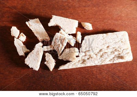 Crushed dietic rye bread on wooden background