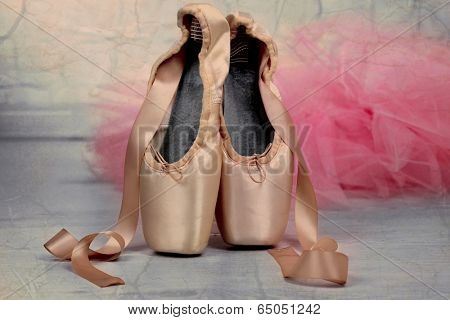 Ballet pointe shoes on floor in dance hall