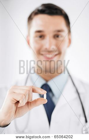 healthcare and medical concept - doctor with pill in hospital
