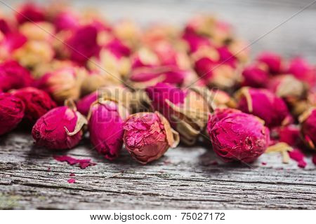 tea rose buds on rustic wooden table