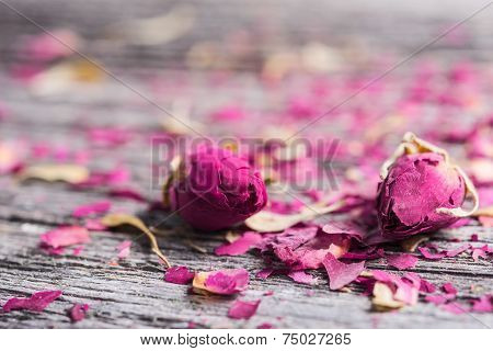 Dry rose buds on rustic wooden table