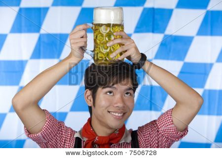 Uomo asiatico avendo Oktoberfest Beer Stein sulla sua testa e sorrisi