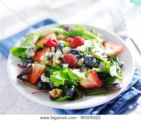 berry salad with walnuts and blue cheese on white table cloth
