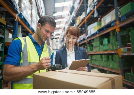 Portrait of manual worker and manager scanning package in the warehouse