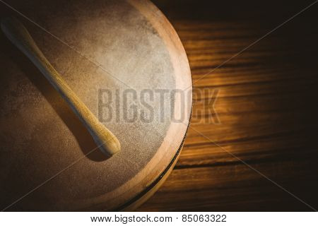 Traditional Irish bodhran and stick on wooden table