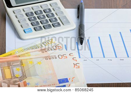 Calculator, graphyc and pen on the table