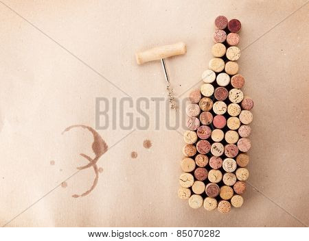 Wine bottle shaped corks and corkscrew over cardboard background. Top view with copy space