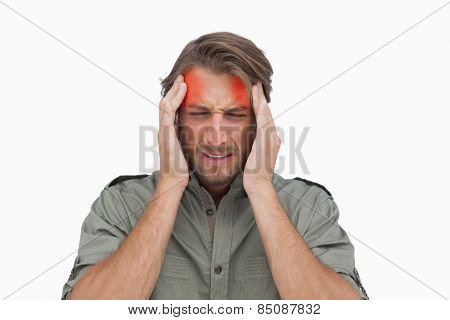 Man wincing with pain of headache on white background