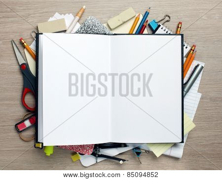 Open book with office supplies