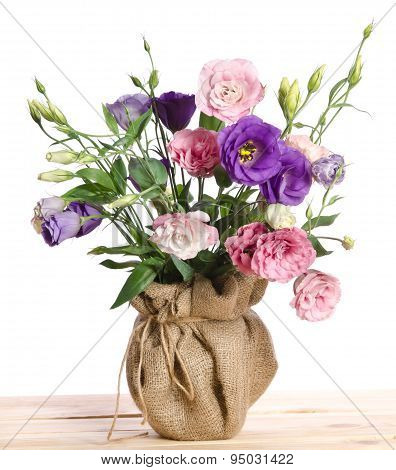 Beautiful Bouquet Of  Eustome Flowers In Flowerpot  On The Wooden Table
