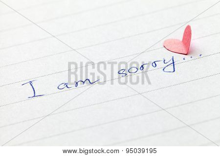 Handwritten phrase I am sorry with heart. Shallow depth of field.