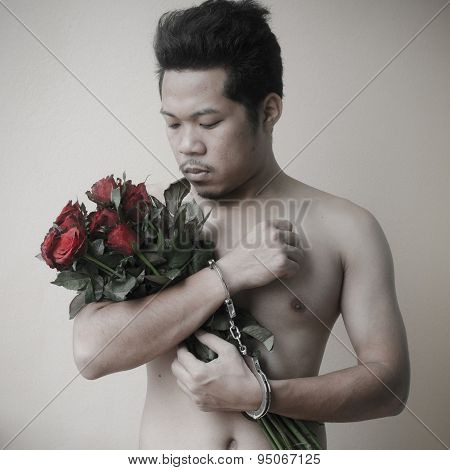 Young Man Holding Red Rose In Hand With Handcuffs