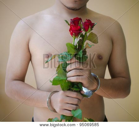 Young Man Holding Red Rose In Hand With Handcuffs