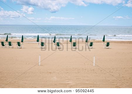 A beach with umbrellas and sun beds on coast