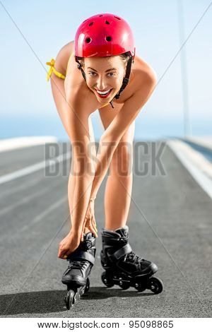 Woman in swimsuit with rollers on the highway