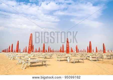 Red Umbrellas And Sunbeds At Rimini Beach - Italian Summer Overview At The Beginning Of The Season