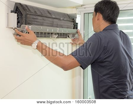 Single electrician man clean fix and maintain air conditioning in the house