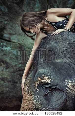 Fine art fashion image of an brunette beauty posing with an elephant