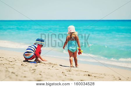 kids play with sand on summer beach, family beach vacation