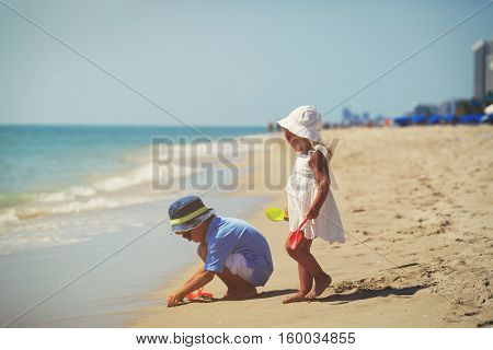 kids play with sand on summer beach, family beach vacation
