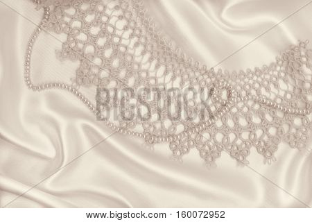 Smooth elegant golden silk or satin with pearls and lace can use as wedding background. In Sepia toned. Retro style