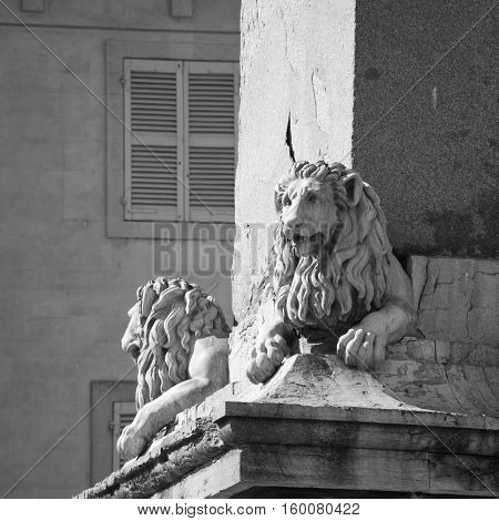Statues of Lions adorning the Arles Obelisk at Place de la Republique in Arles, France. Black and white.