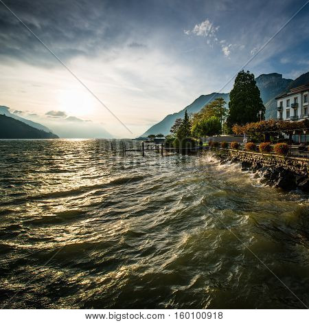 Storm and wind on the lake of Swiss Alps. Splash of waves in the setting sun. High Dynamic Range Image.