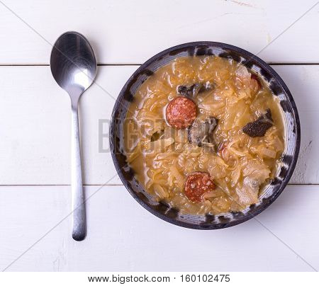 Christmas cabbage soup on white wooden background.