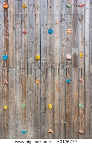 Grunge surface of old wood climbing wall with toe and hand hold studs.