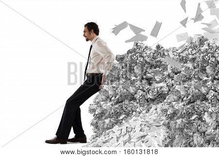 Businessman pushing with fatigue a big pile of paperwork