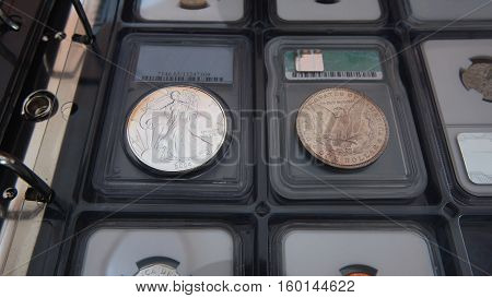 Old American silver dollar and new American silver dollar on album for coins collection - Numismatic scene