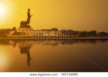 soft filter beautiful landscape silhouette buddha statue sacred with sunset and reflection shadow on the lake and clear sky at phutthamonthon in Thailand