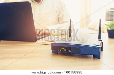 closeup of a wireless router and a man using Laptop and notebook computers on living room at home ofiice