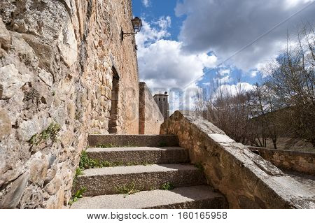 Ancient street next to San Cosme and San Damian Collegiate Church, Covarrubias, Burgos, Spain. It was built based on an earlier Romanesque church. It is a 15th century Gothic church. It has a Latin cross floor plan three naves and a crossing