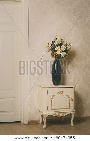 cozy stylish vintage corner of the ivory bedroom with flovers in vase